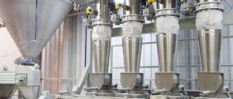 Planta de dosificación de polvo con tolvas y válvulas de acero inoxidable.