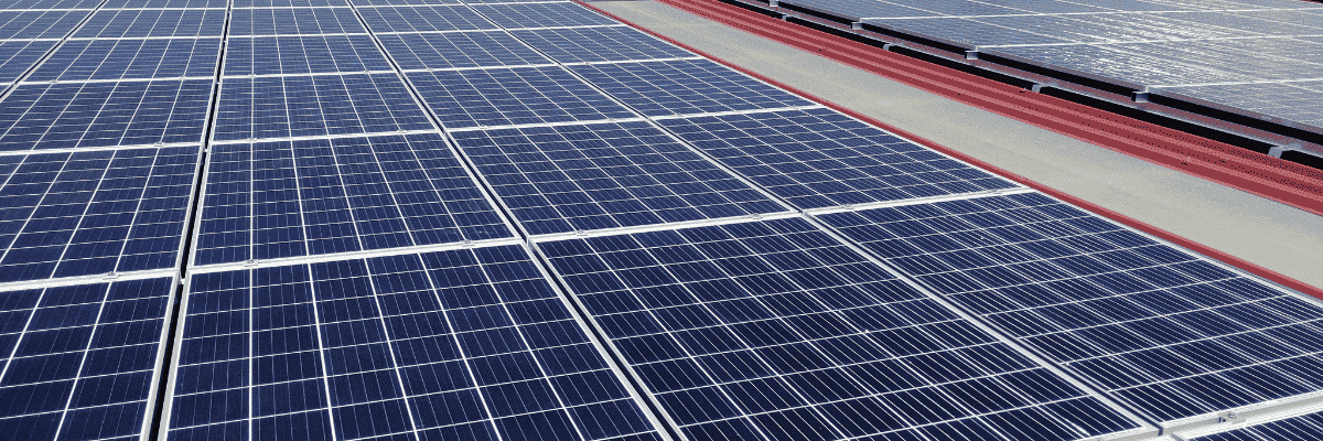 Paneles solares azules instalados en un tejado bajo un cielo despejado.