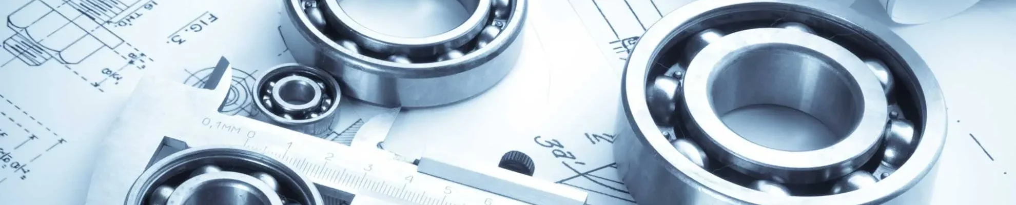 Rodamientos y calibre sobre planos de ingeniería.